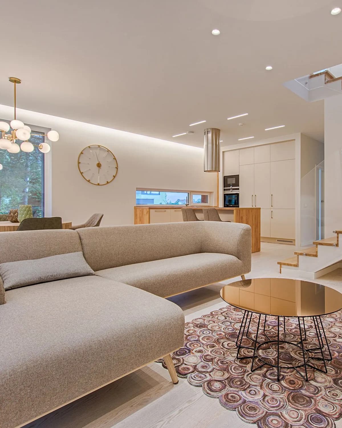 Séjour aménagé par un architecte d'intérieur, canapé beige et luminaires en laiton