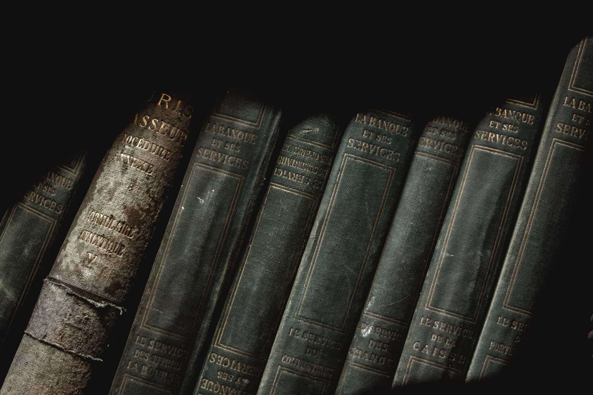Reliures anciennes d'ouvrages de droit dans la pénombre d'une bibliothèque