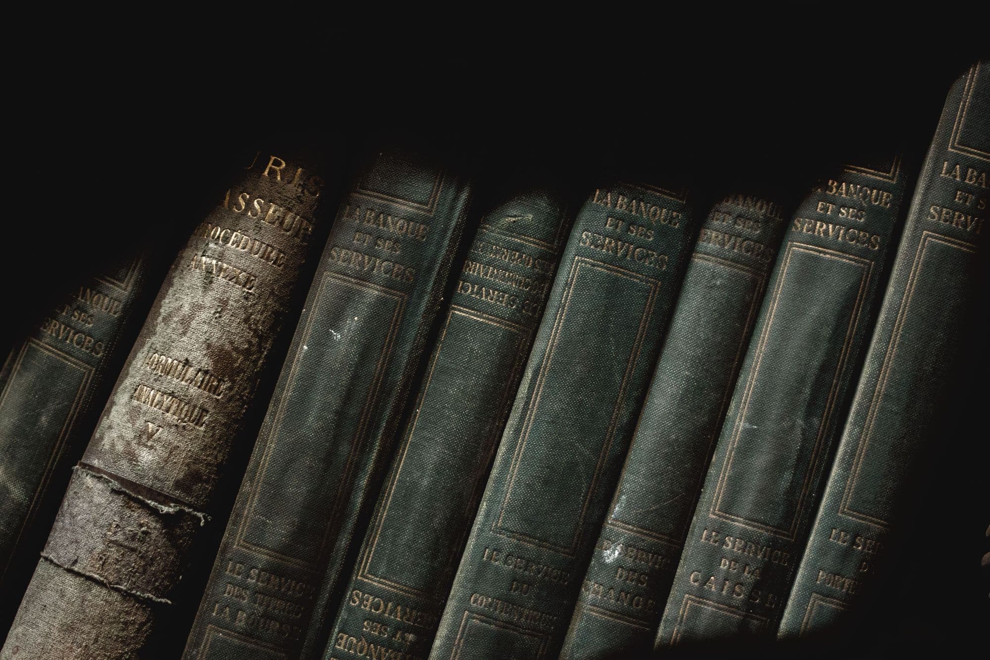 Reliures anciennes d'ouvrages de droit dans la pénombre d'une bibliothèque