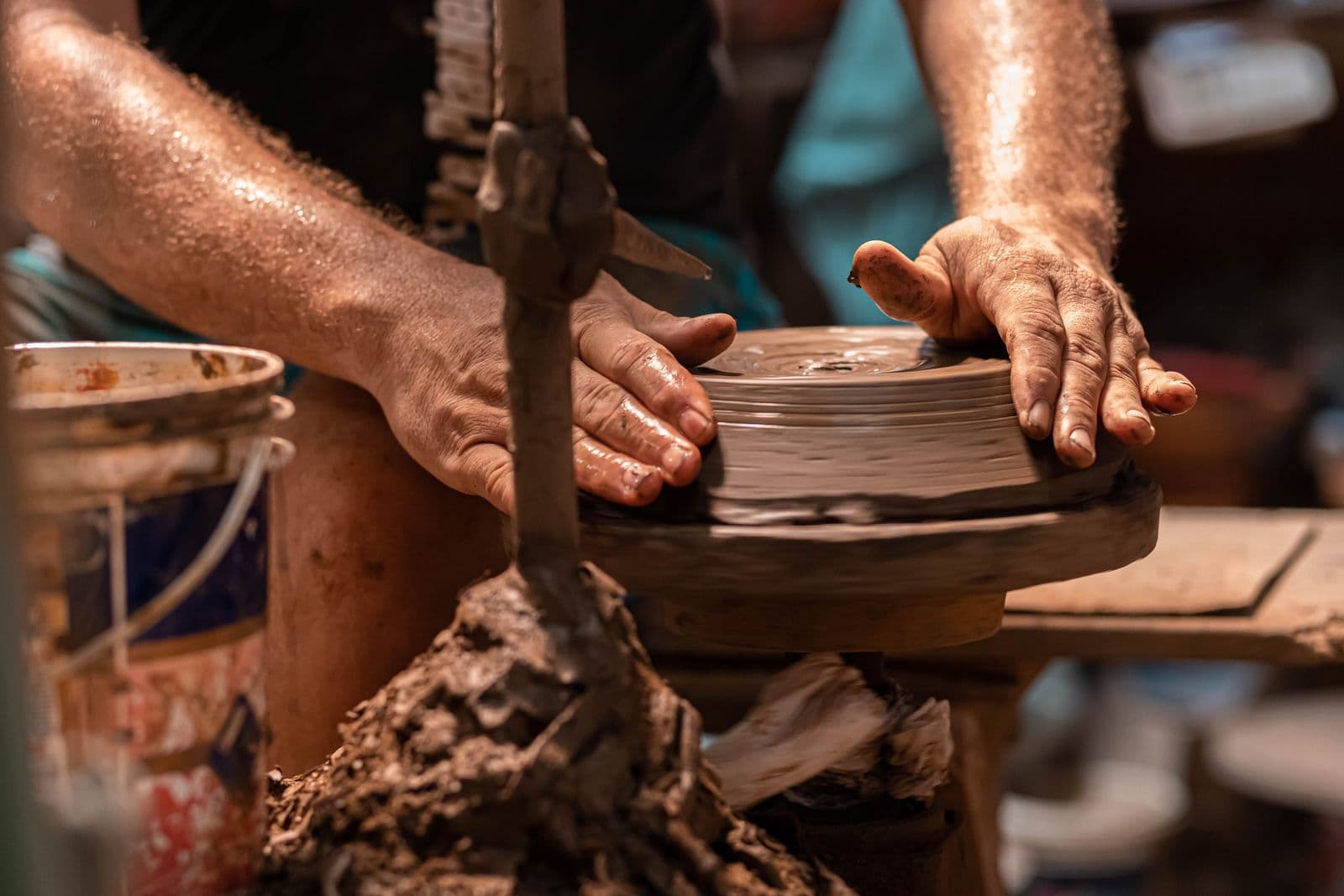 Mains d'un artisan façonnant une pièce au tour
