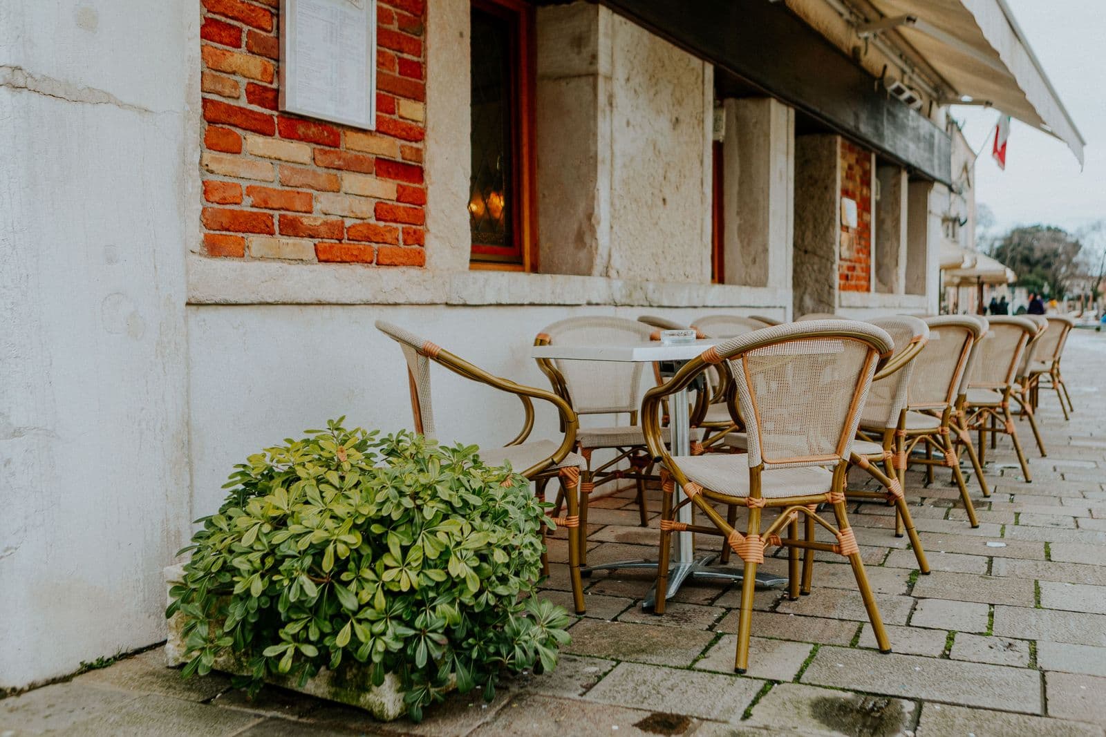 Terrasse de restaurant, chaises en rotin sur le trottoir