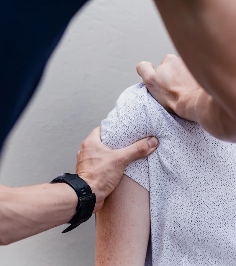 Kinésithérapeute mobilisant l'épaule d'un patient